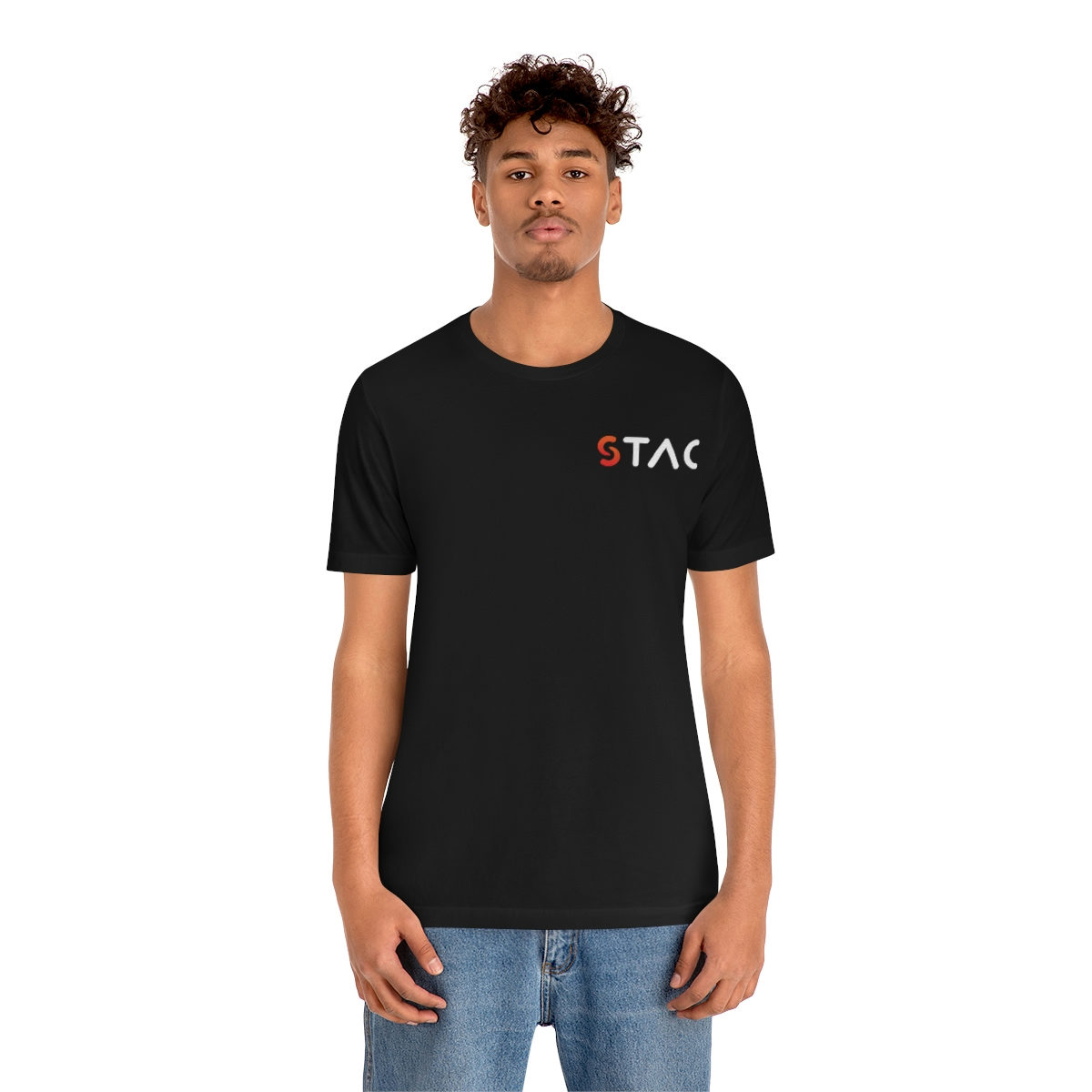 A young medium skin tone male model wearing a black t-shirt with stylized "STAC" over the left breast.