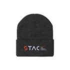 Flat front view of dark ash colored beanie-style knit hat with the STAC logo embroidered on the folded area.
